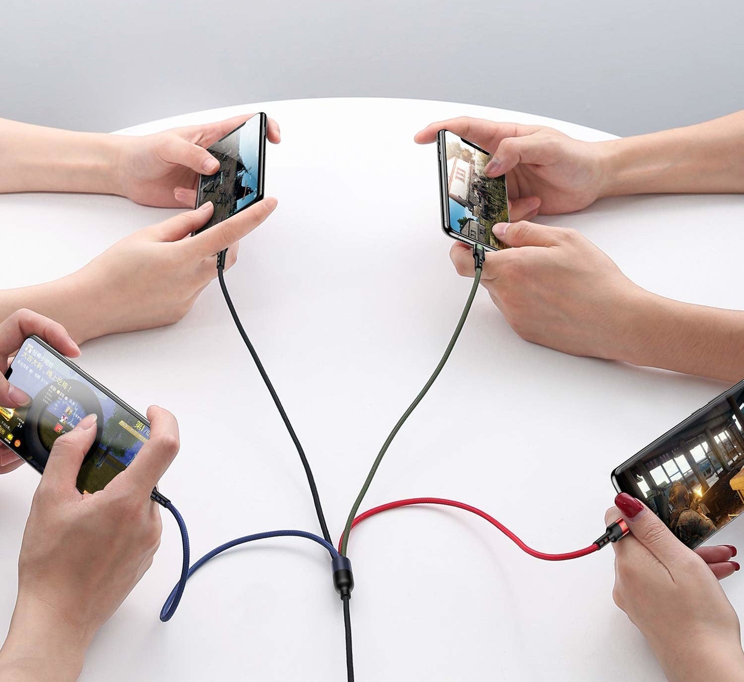 a set of four people each charging a device on the four-ended cable