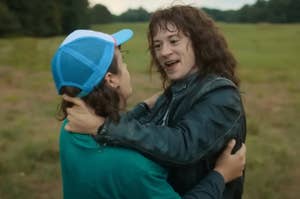 Dustin and Eddie from Stranger Things embracing in a field