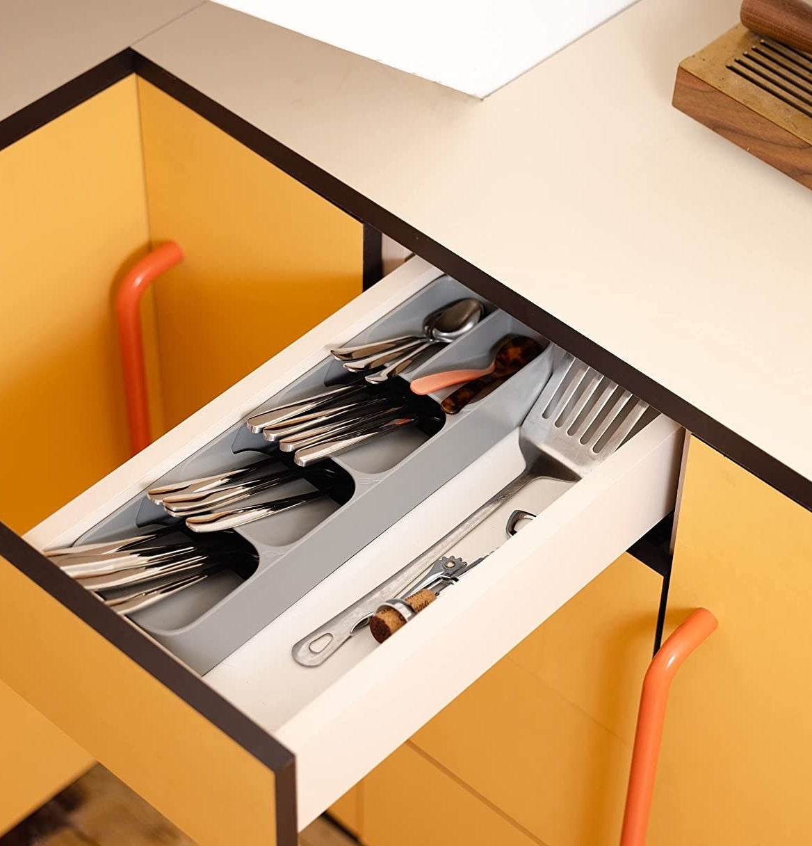 a cutlery tray in a drawer in a vibrant kitchen