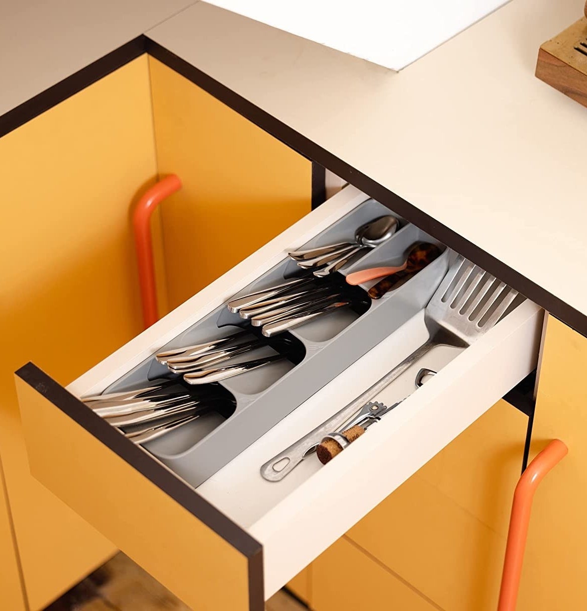 a cutlery tray in a drawer in a vibrant kitchen