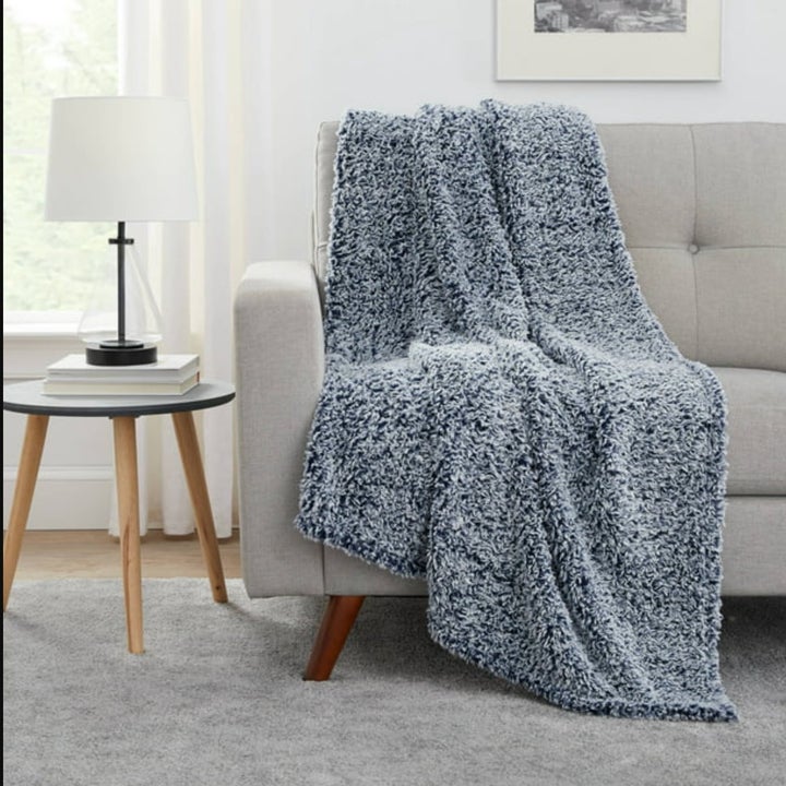 the blue fuzzy blanket on a couch in a decorated living room