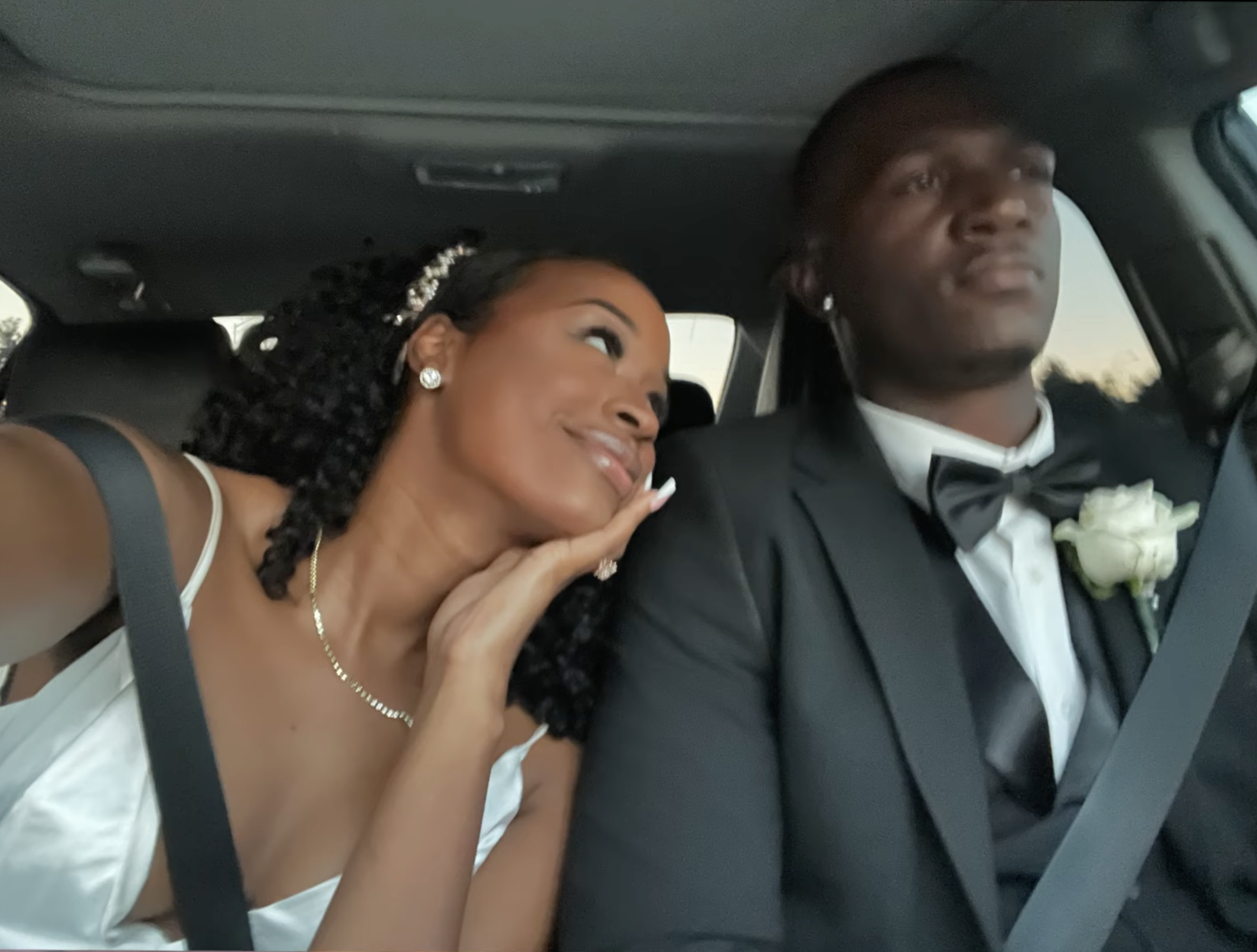 The couple in a car on their wedding day