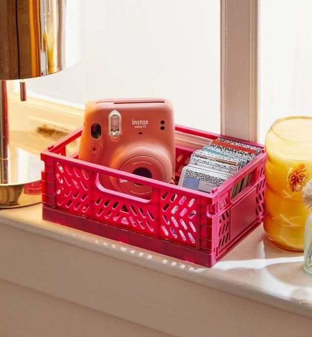 a vibrant crate with a camera and notebooks inside