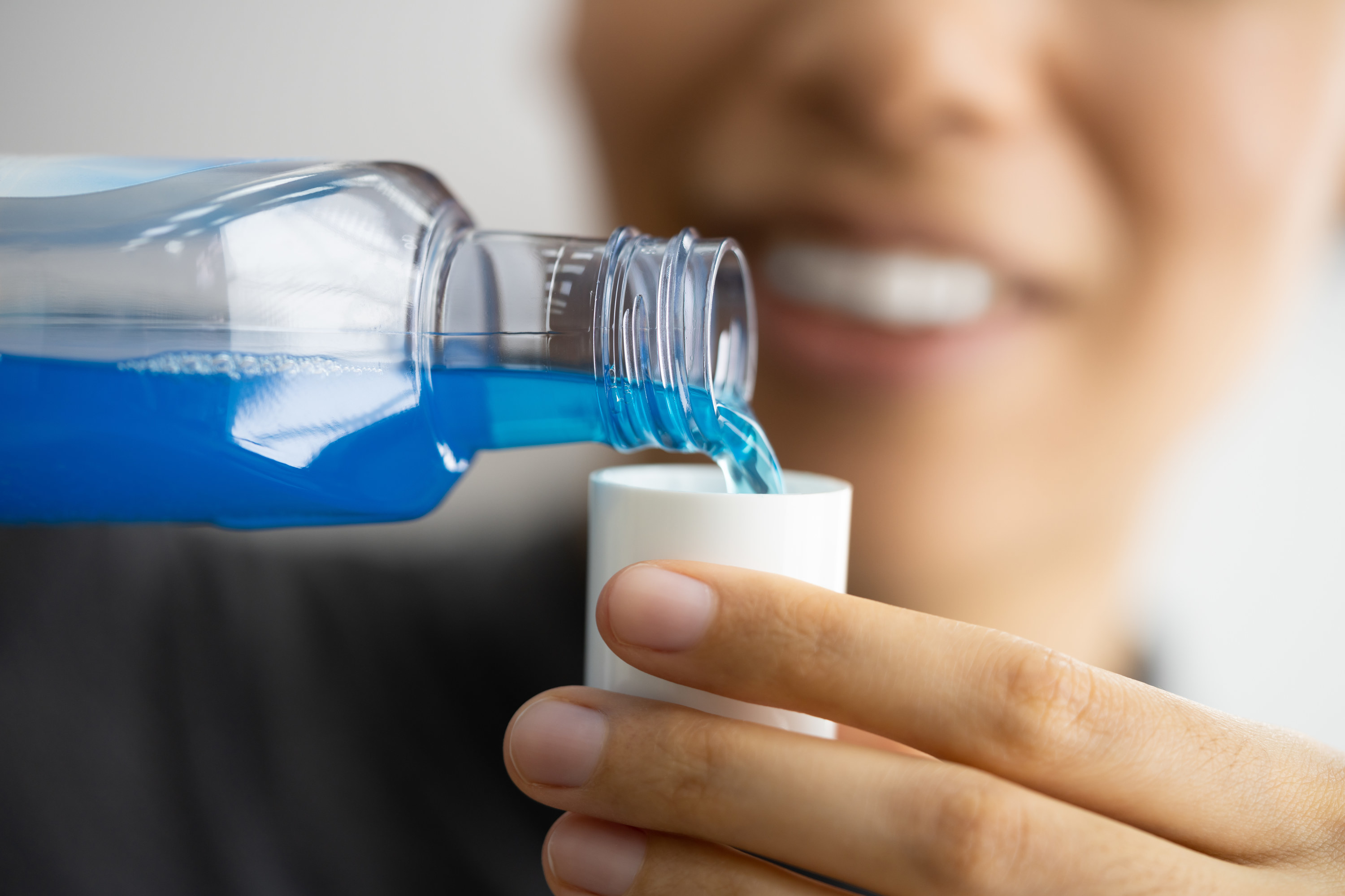 mouth wash being poured into a mini cup