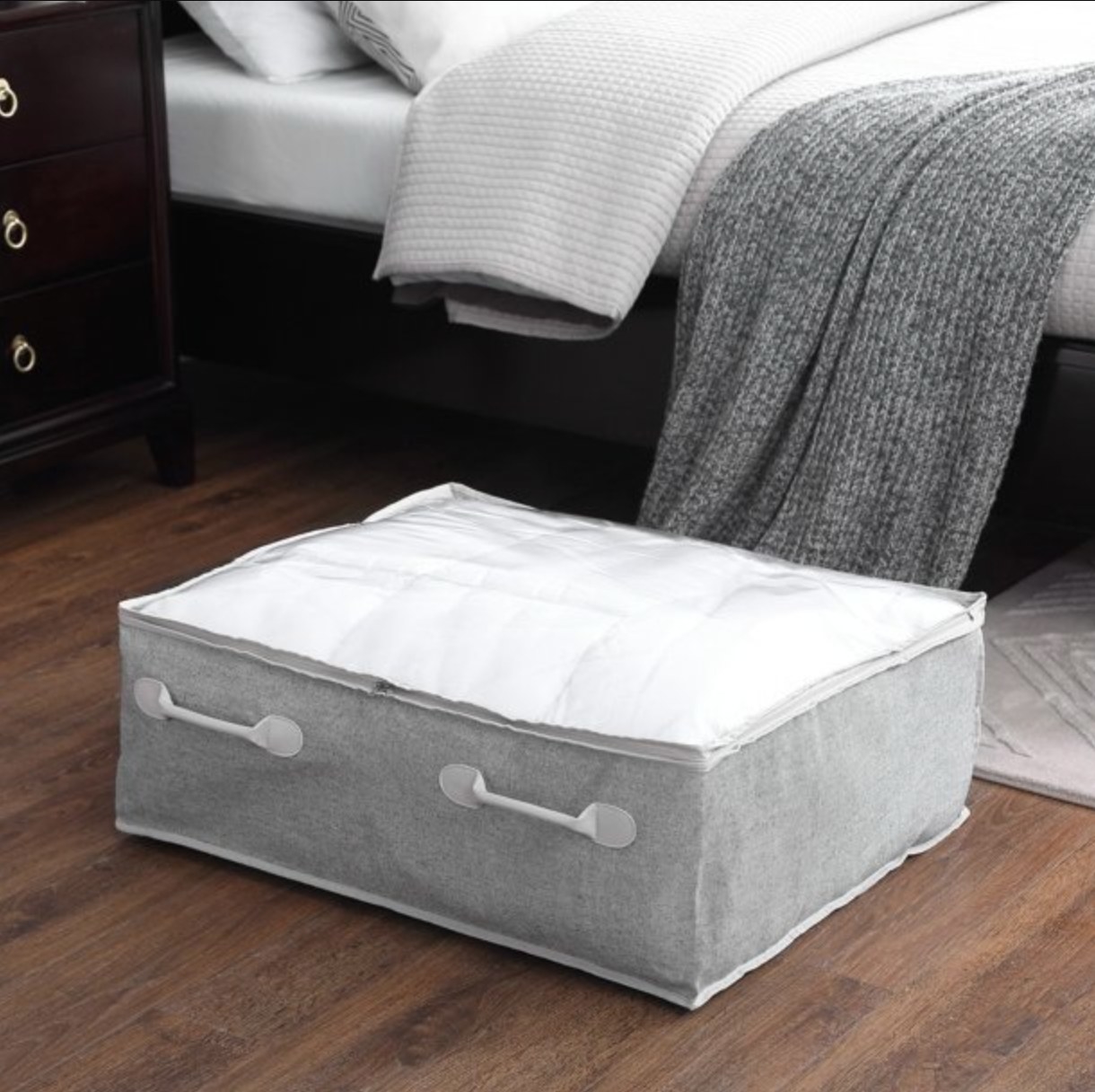 the grey fabric bin pulled out from under a decorated bed