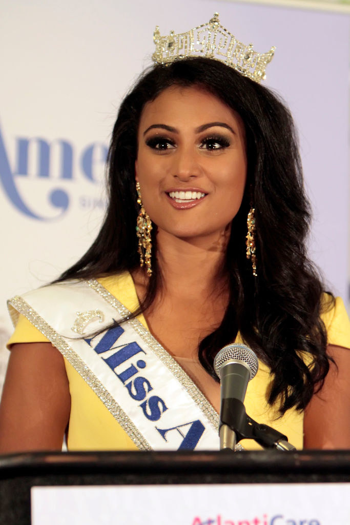Davuluri wearing her crown and talking into a mic