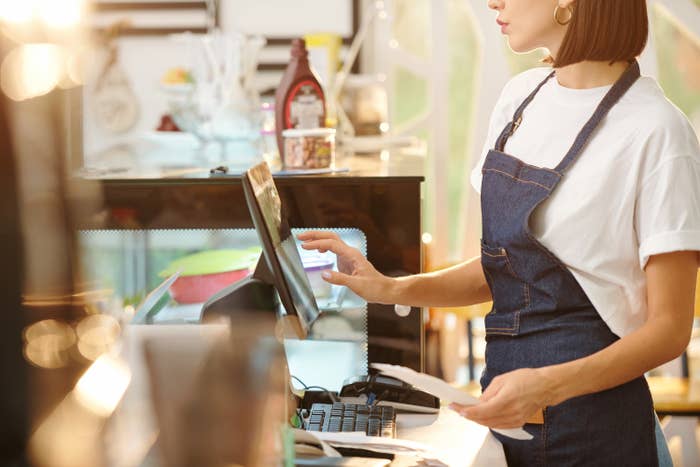 cashier&#x27;s hands typing on a screen