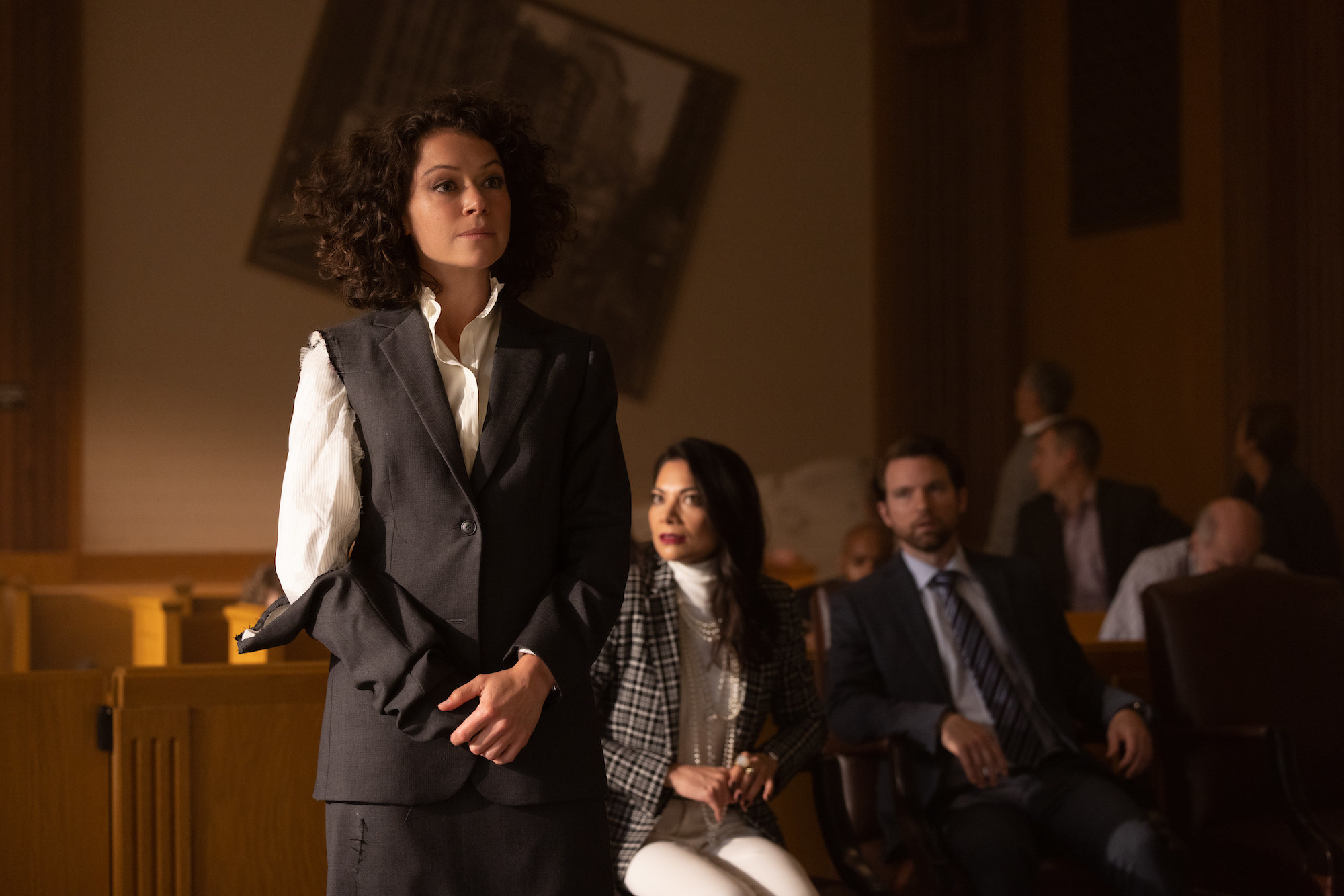 Tatiana Maslany stands in court with a ripped sleave
