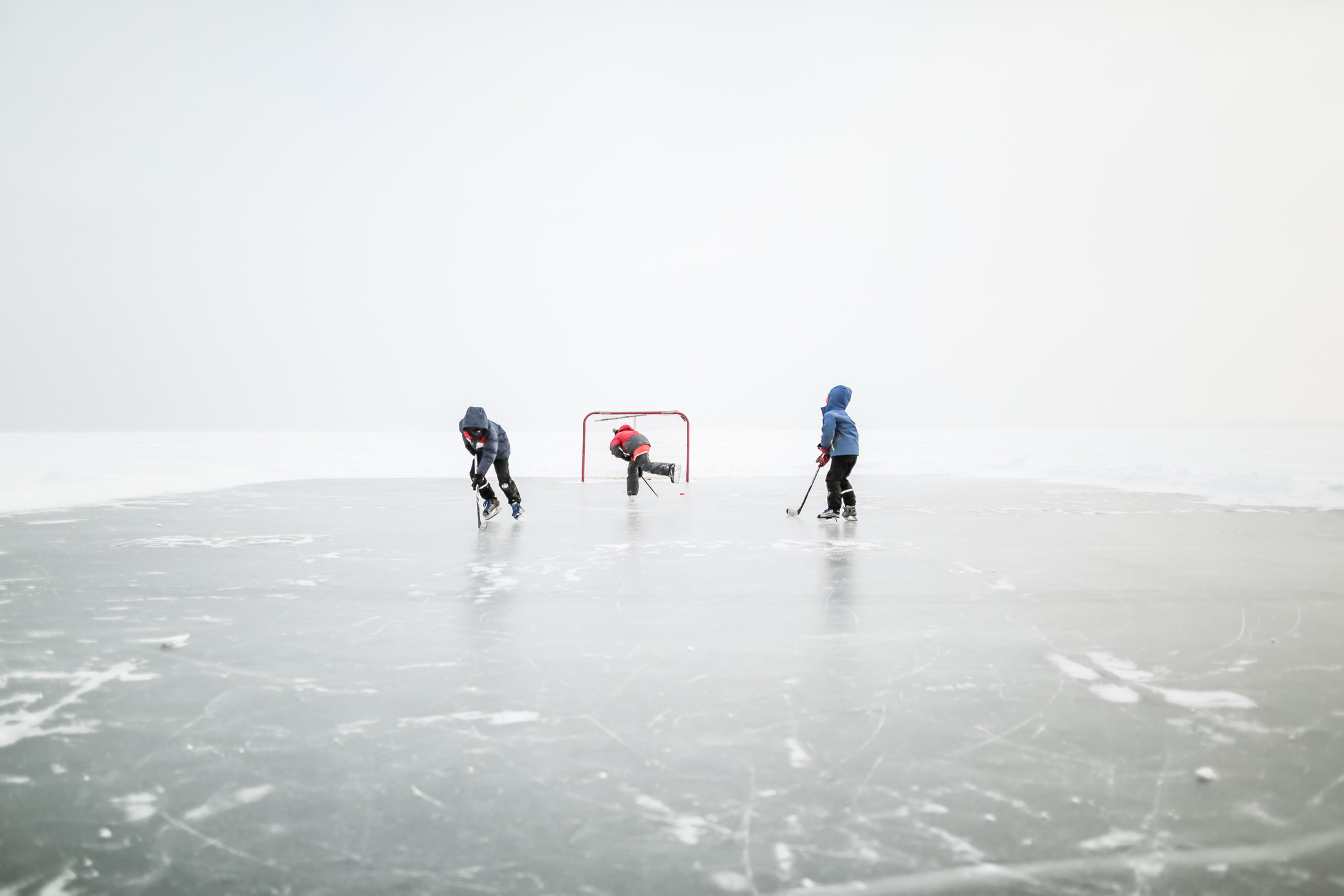boys playing hockey on a frozen lake