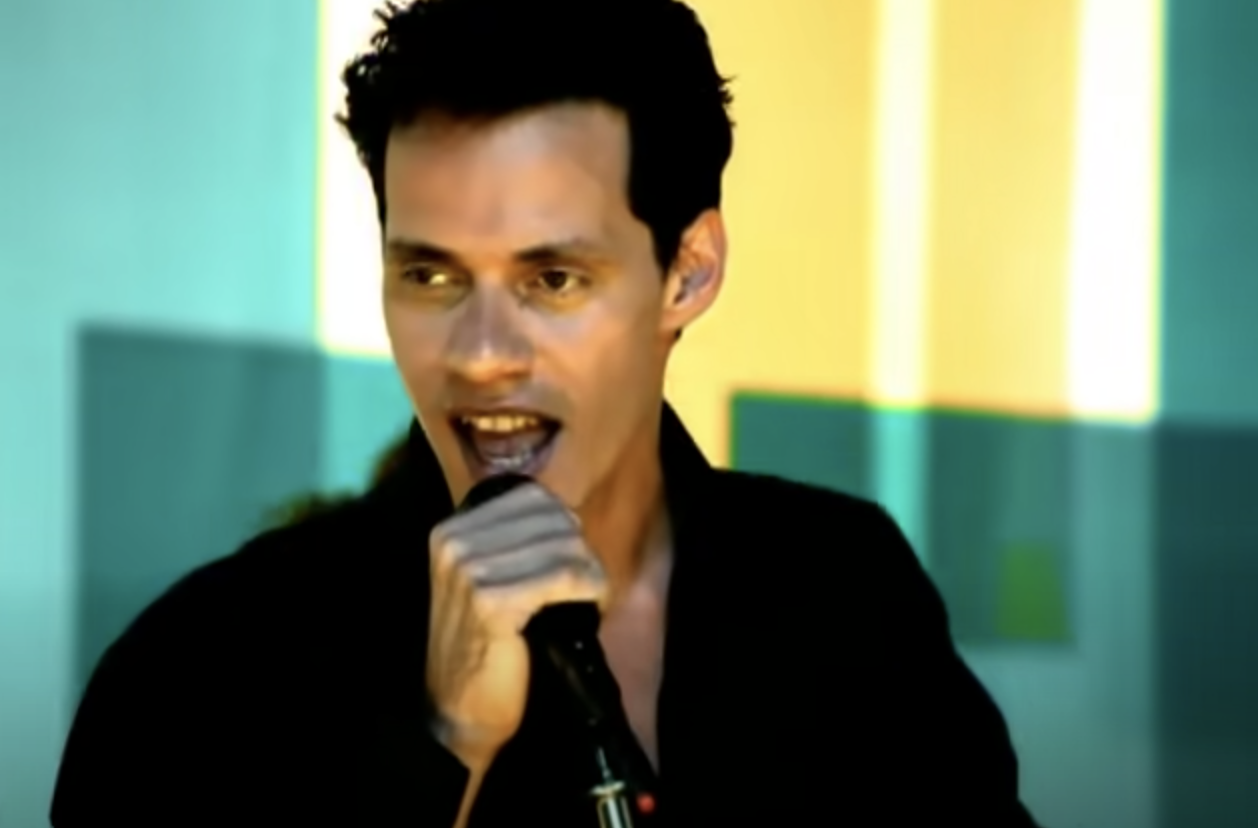 Marc Anthony sings into a microphone because he needs to know