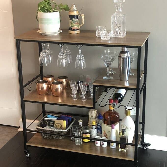 a reviewer photo of the bar cart with bottles and glassware