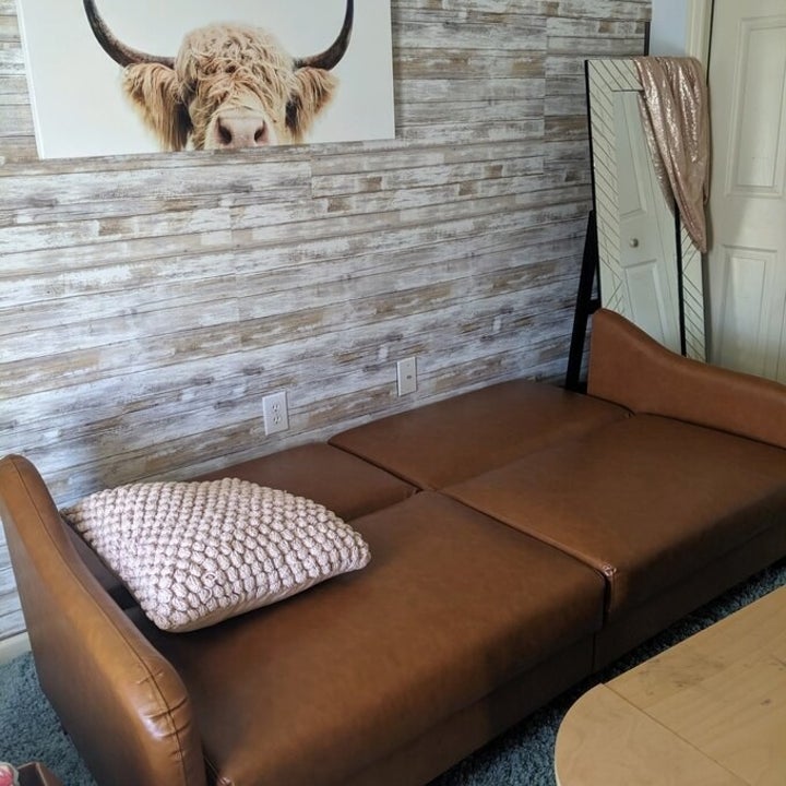 the same reviewer showing the sofa converted into a bed