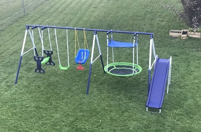 a reviewer photo of the playset in a yard