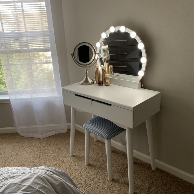 a reviewer photo of the white vanity in a bedroom
