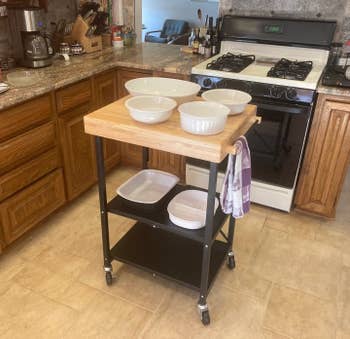 reviewer image of the black cart with wood top in a kitchen
