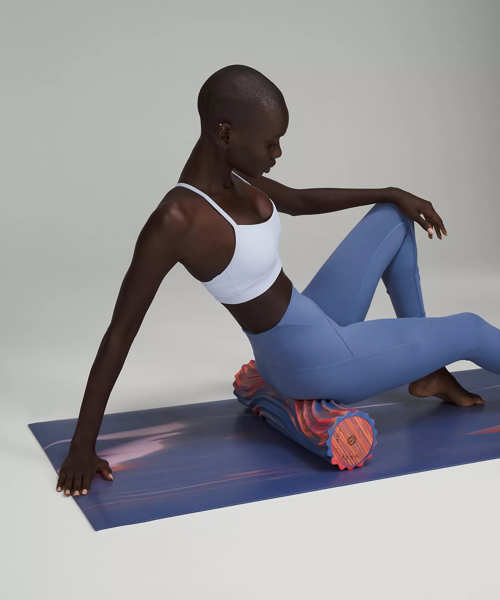 A person on a yoga mat using the double roller