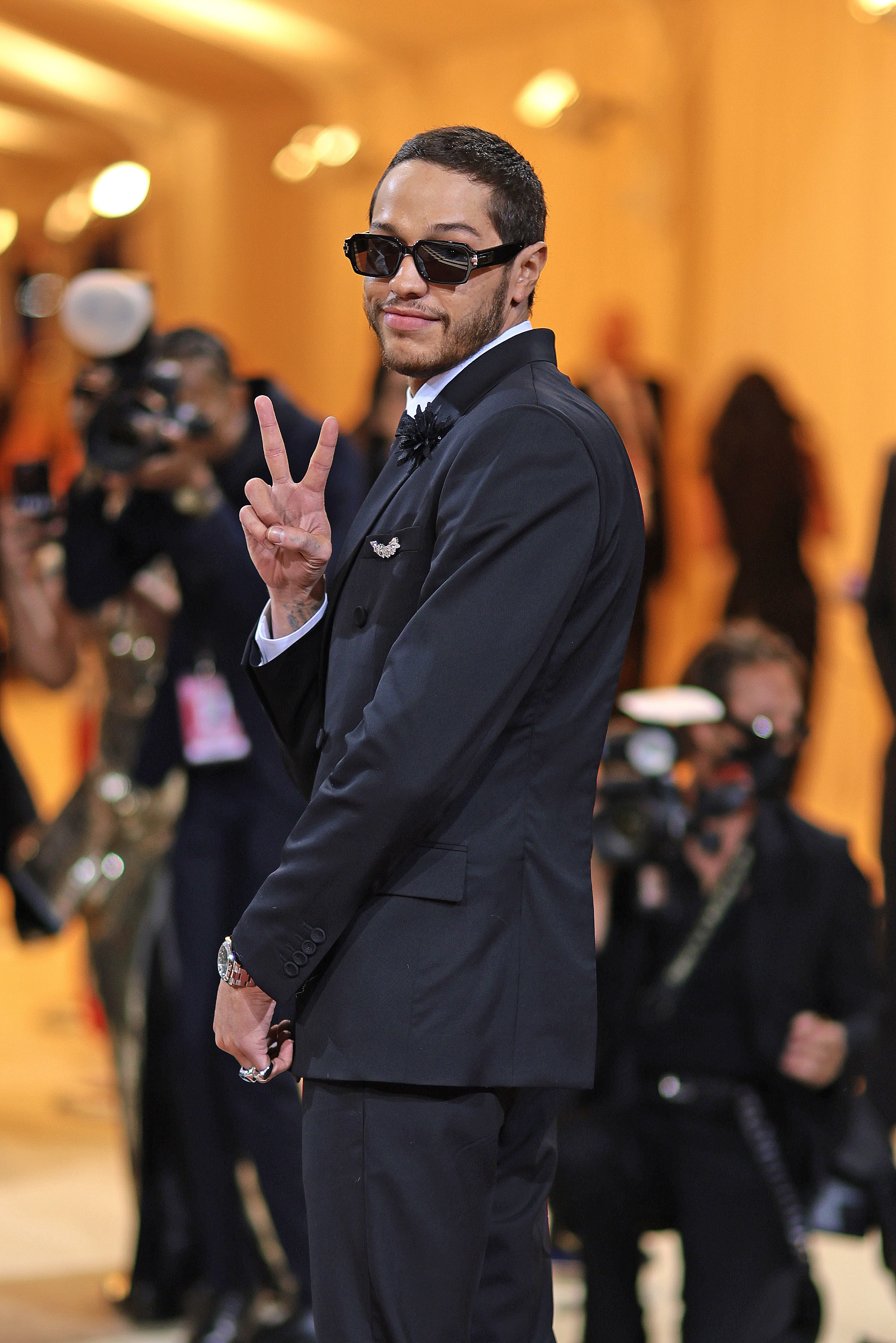 Pete in a suit at the MET Gala giving the peace sign
