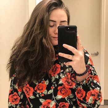 a reviewer wearing the top in a black and red floral print