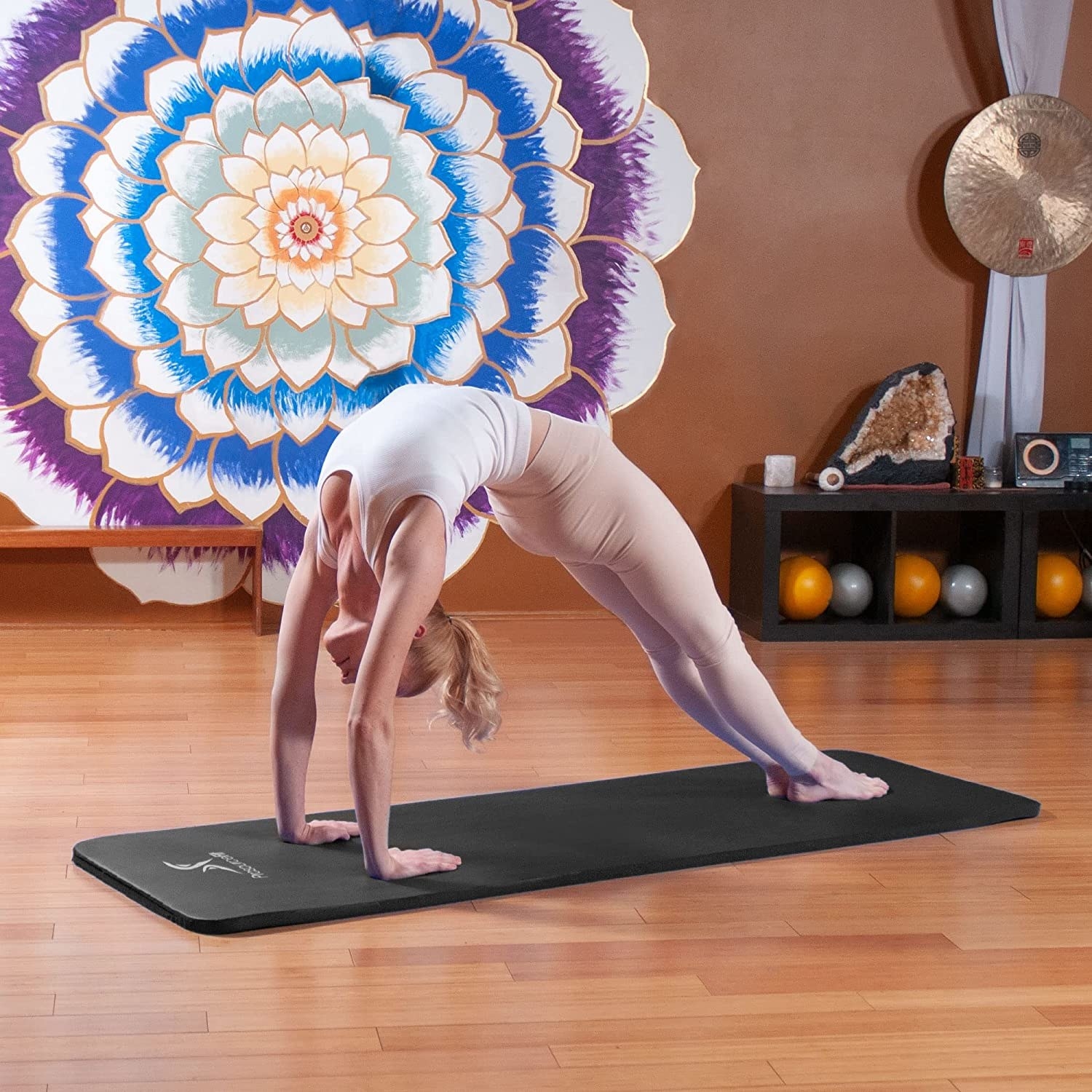 Someone doing a yoga pose on the mat in a studio