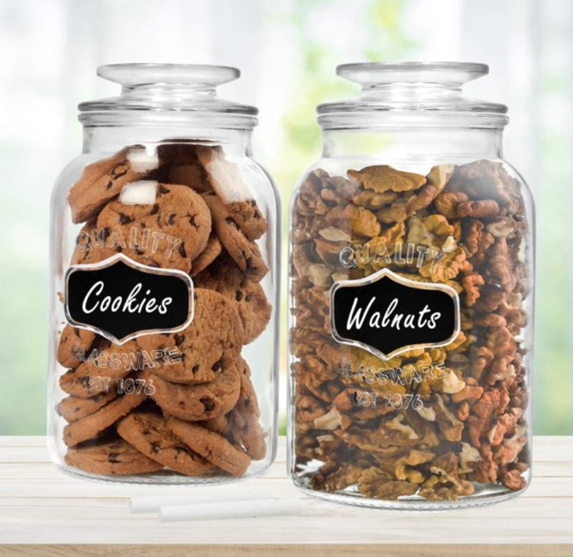 Storage jars on a counter with walnuts and cookies inside them