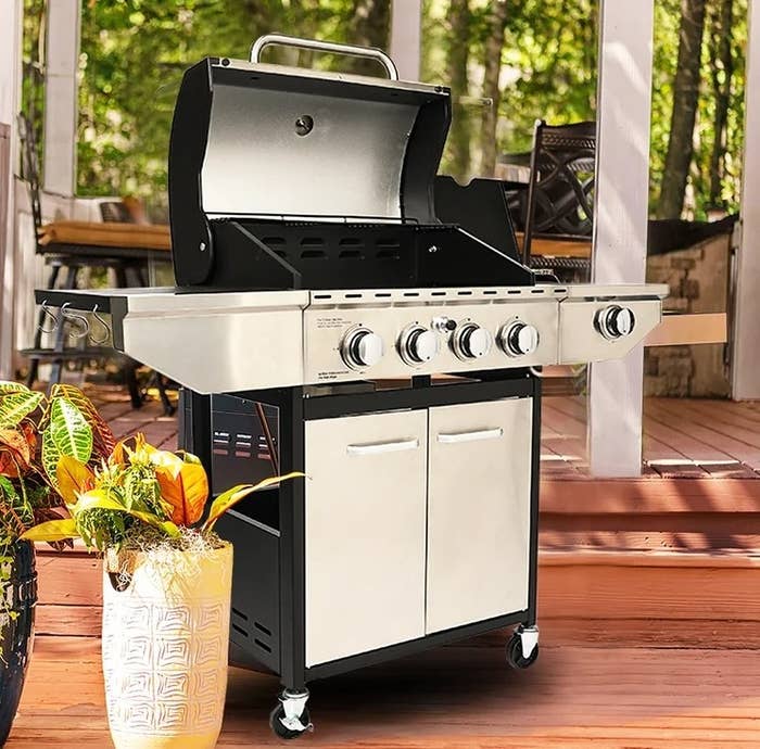The gas grill with side burner and cabinet