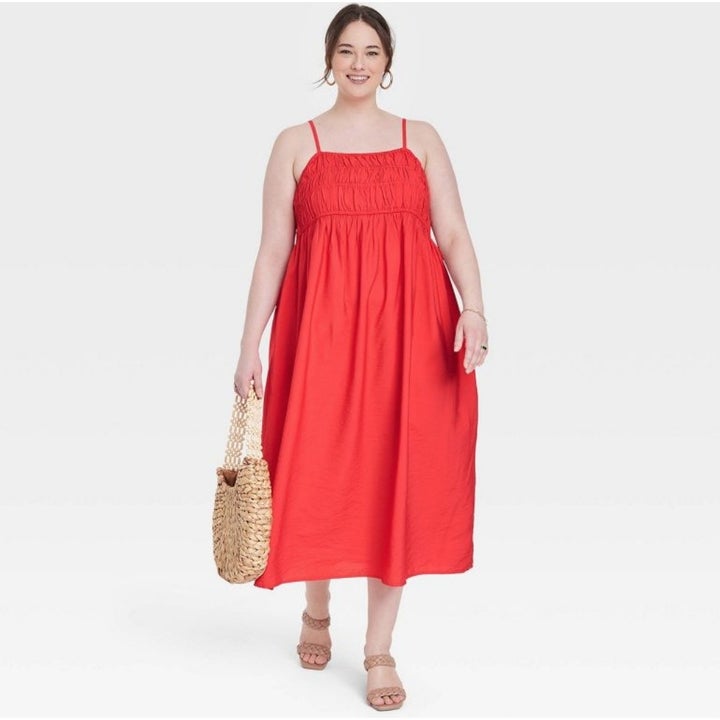 A model wearing a  red spaghetti strap dress
