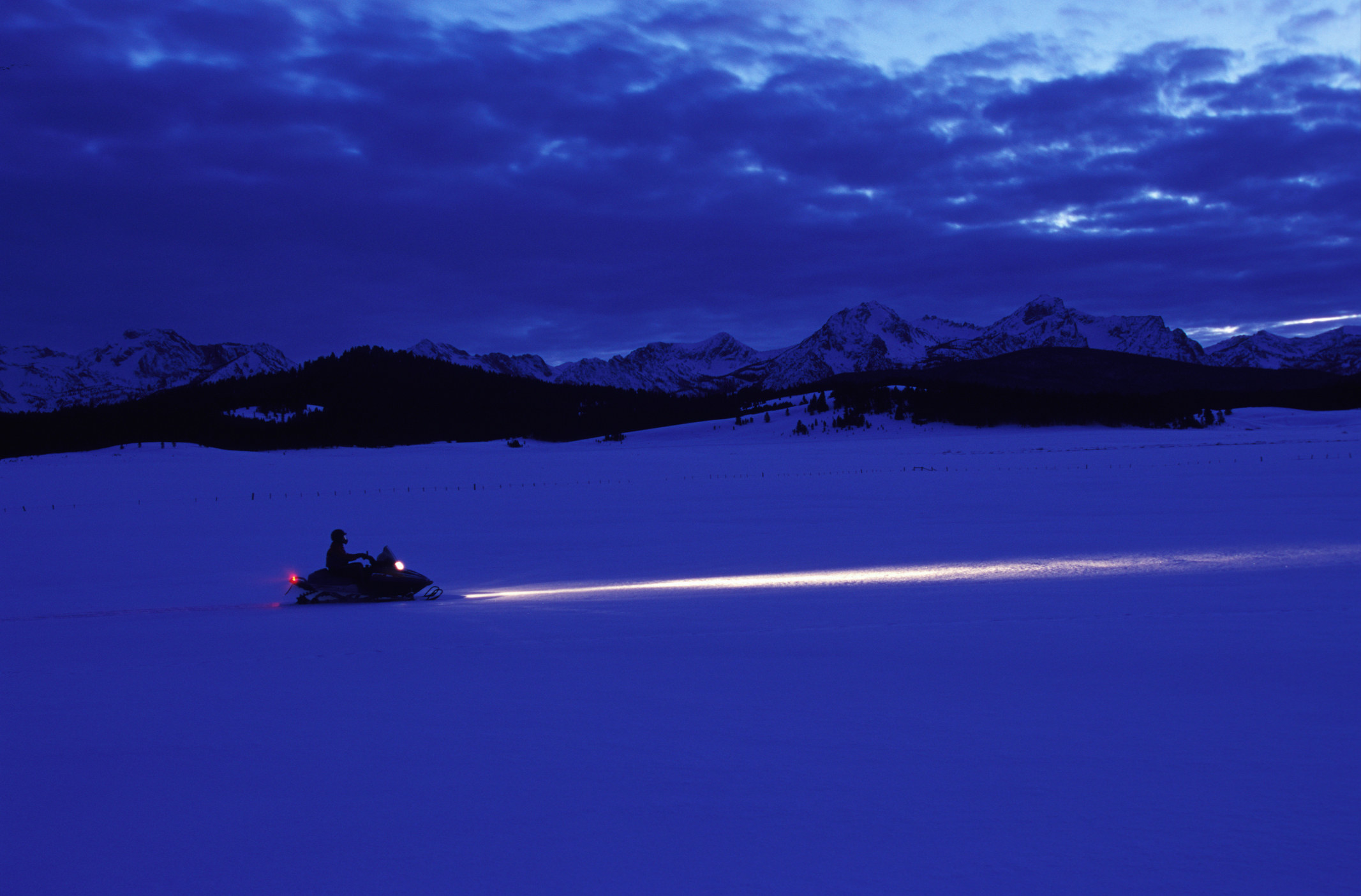 someone driving a snowmobile in the dark