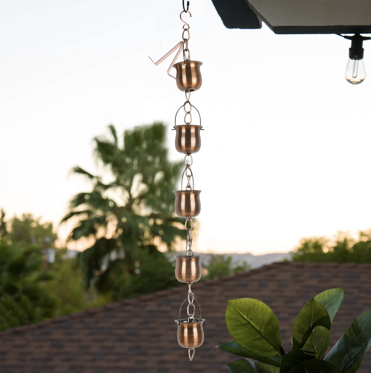 the copper rain chain hanging from a gutter