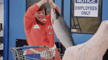 Melissa McCarthy adding a giant fish to her shopping cart