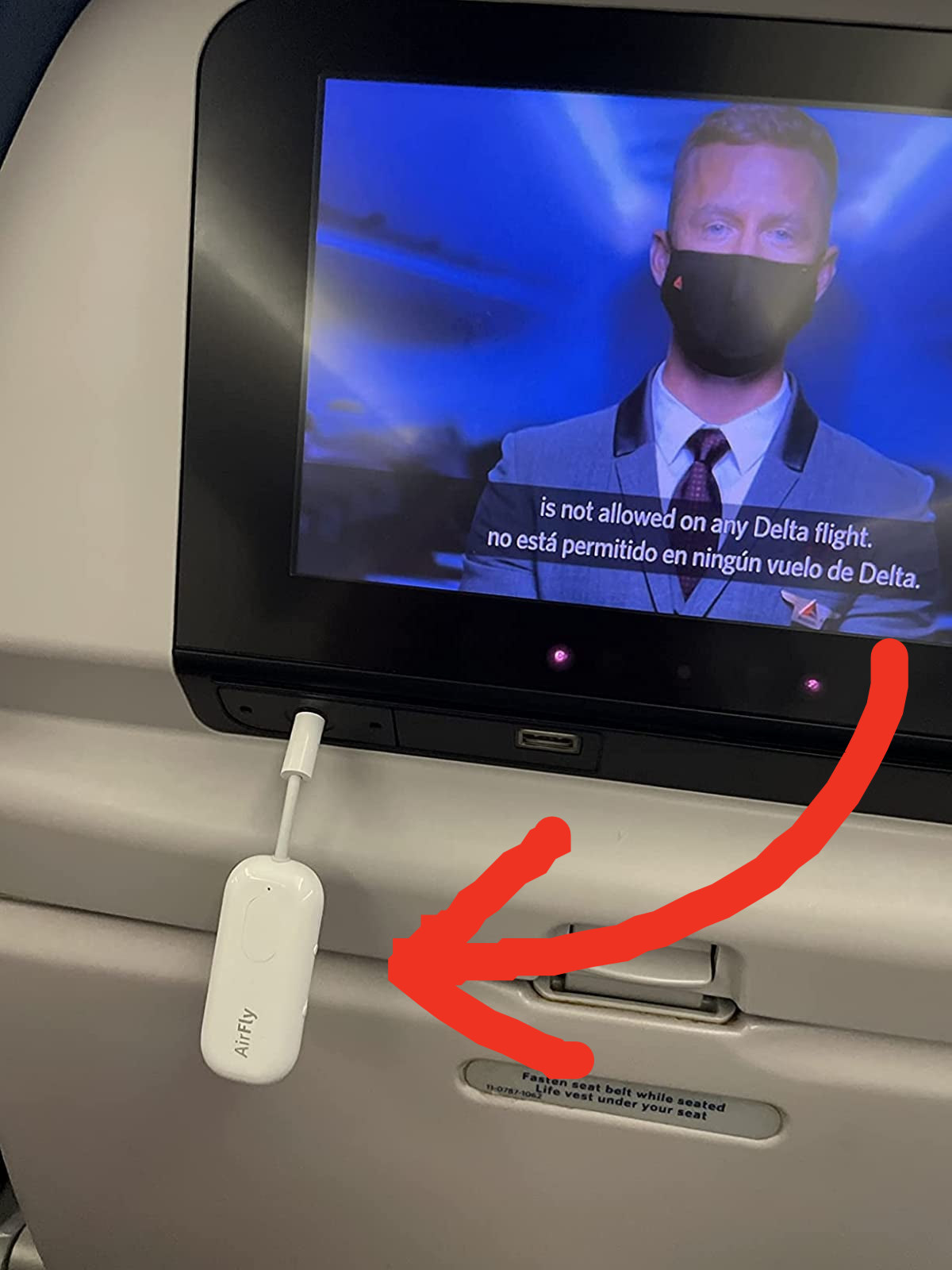 Reviewer pic of the AirFly connected to a TV on a flight
