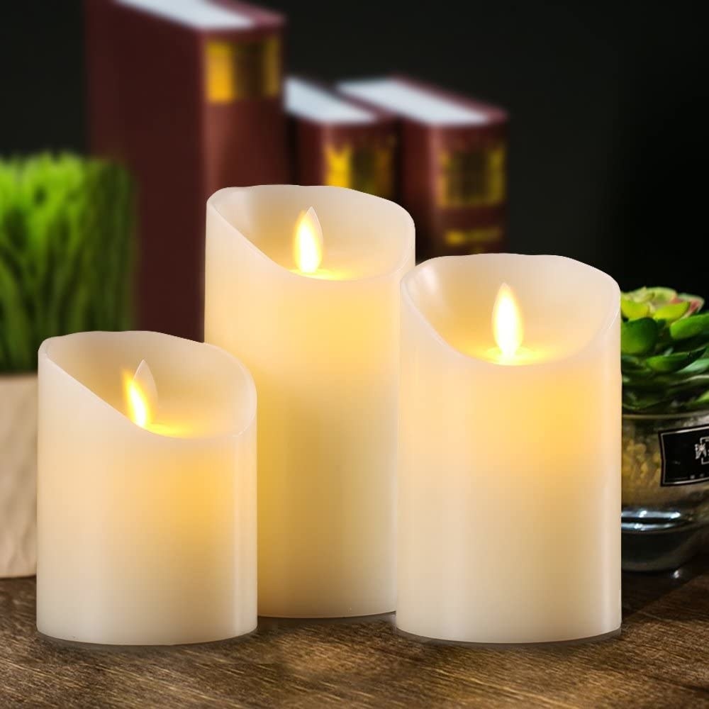 three flameless candles on a wood surface