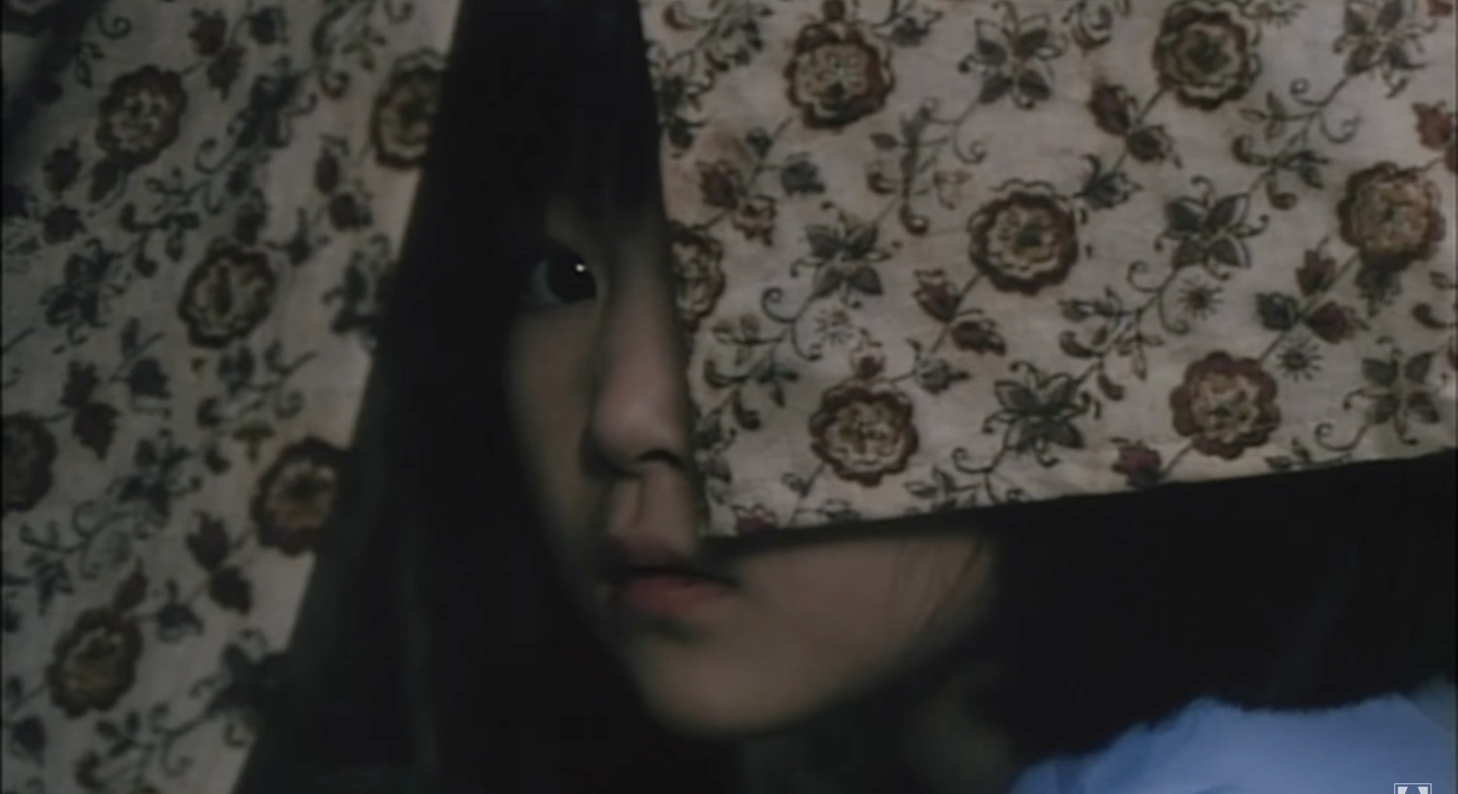 A scared-looking child whose face is partially covered