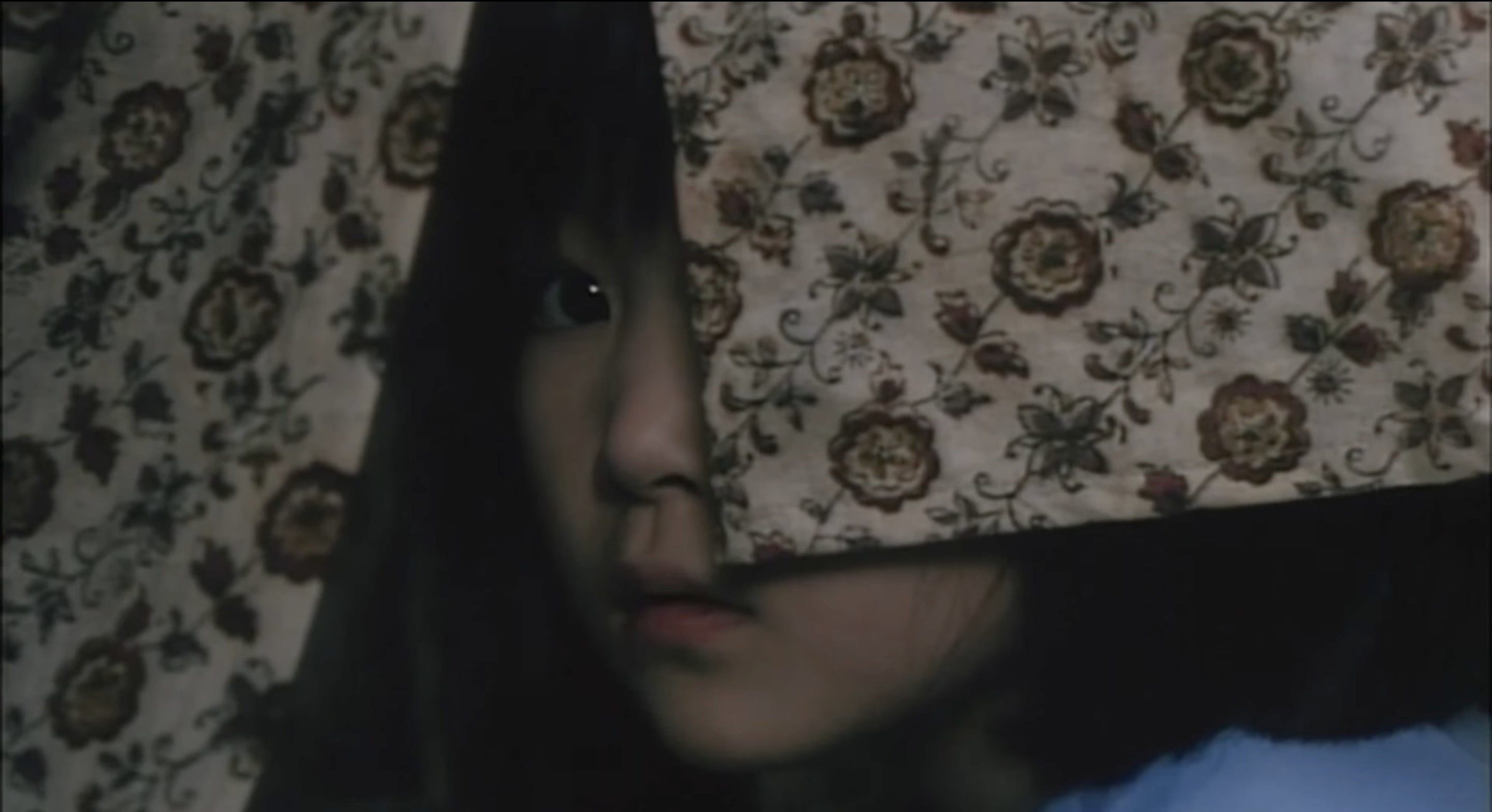 A scared-looking child whose face is partially covered