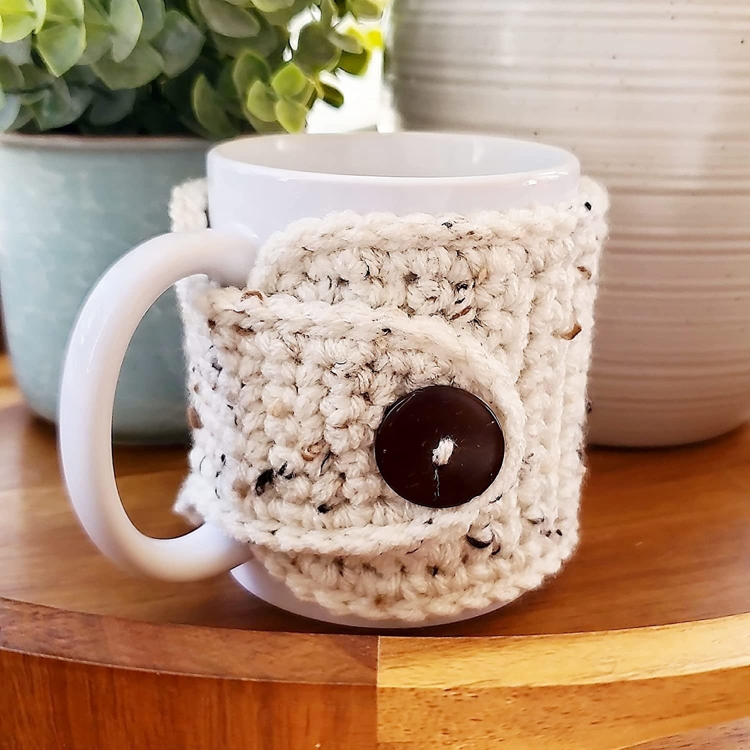 the white mug sweater with a brown button on a white mug