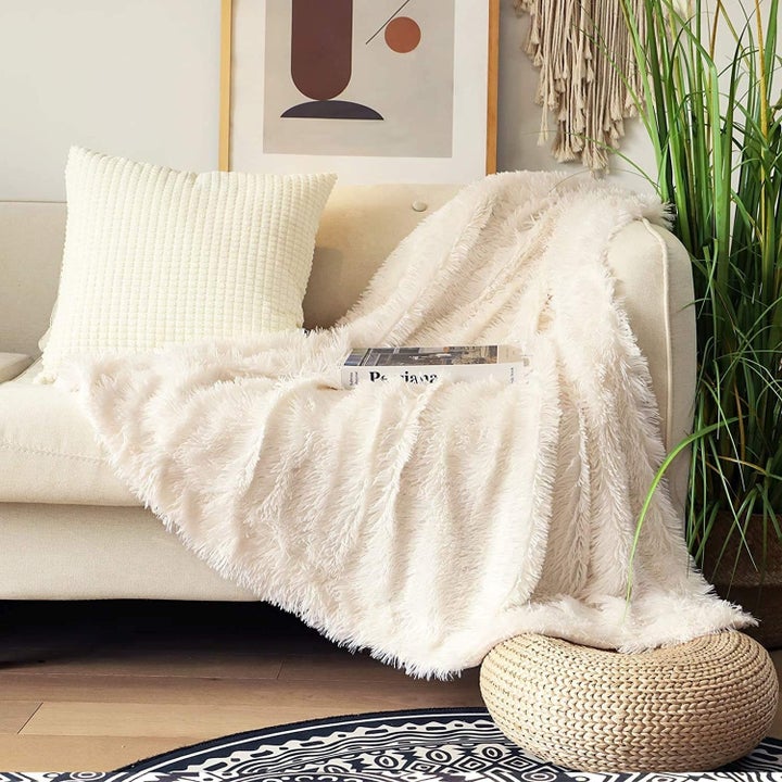 the cream colored throw blanket on a couch