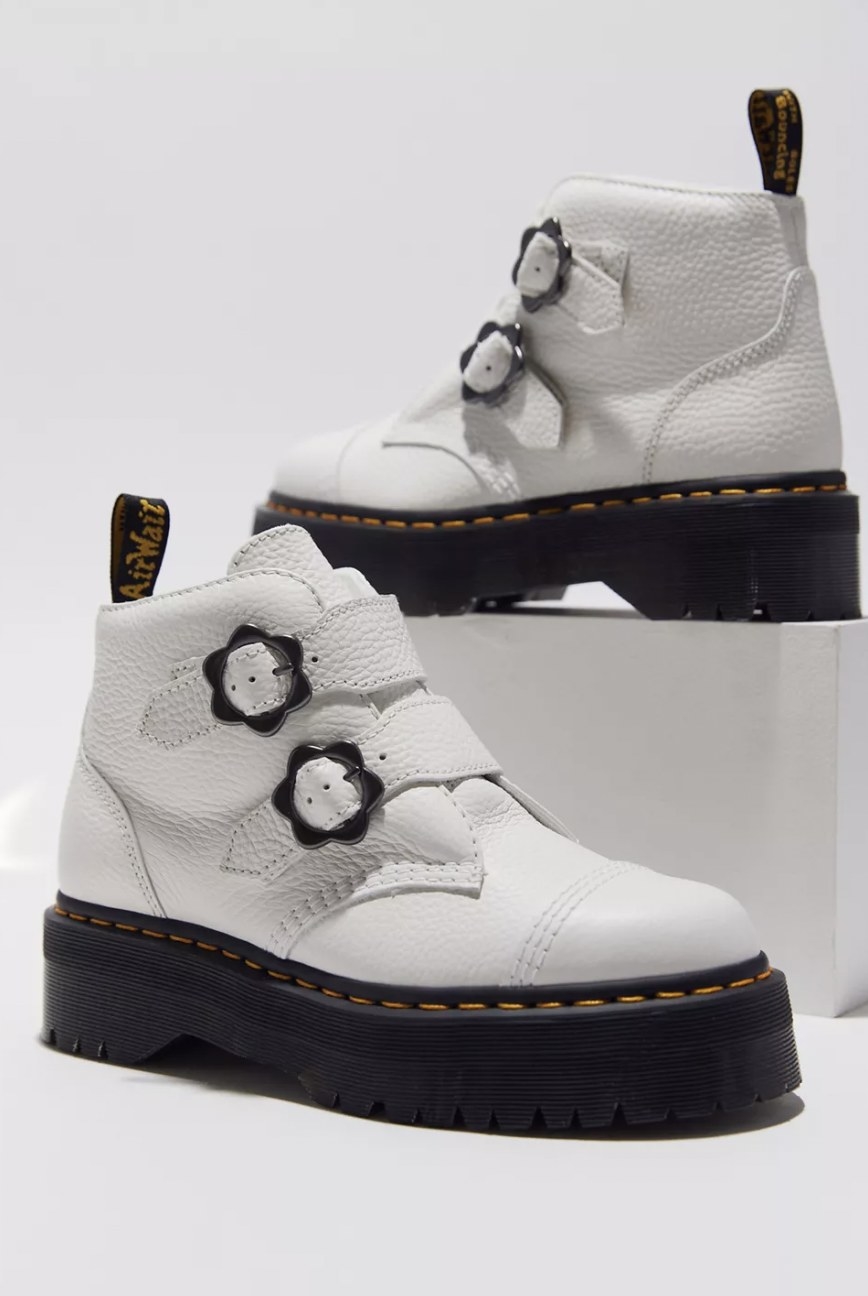 The white leather boots with two grey flower buckles on the straps