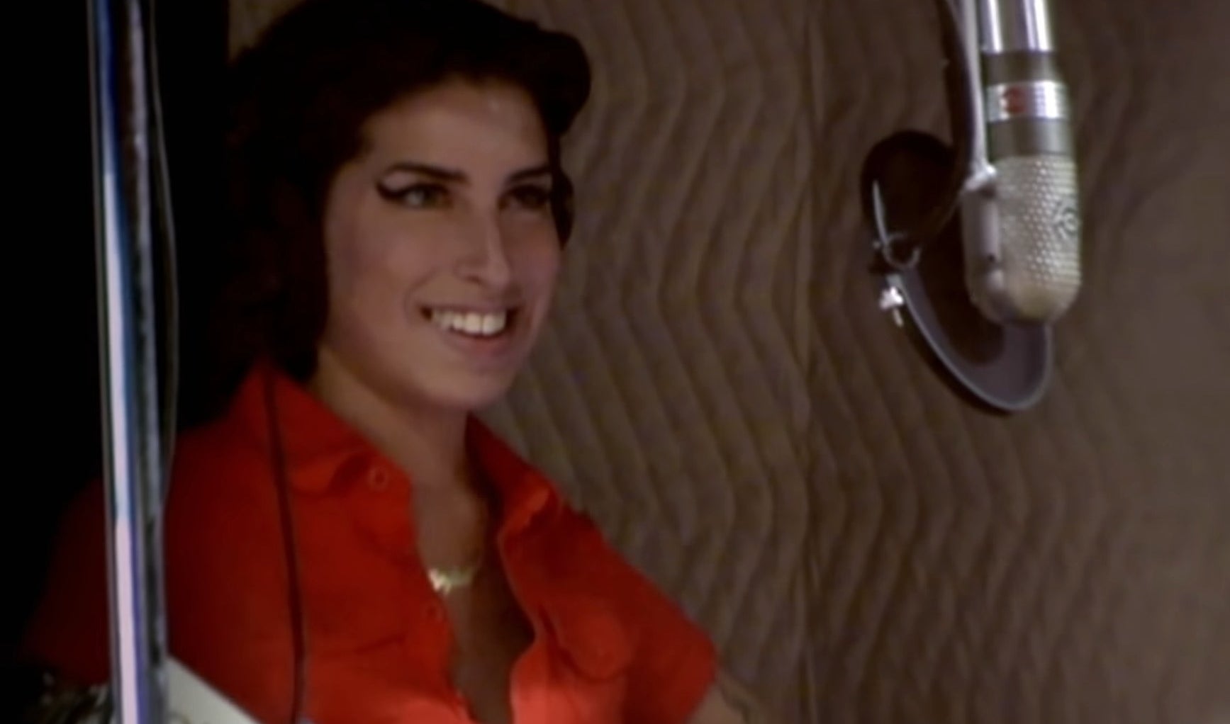 Archival footage of Amy Winehouse in front of a microphone in the documentary &quot;Amy&quot;