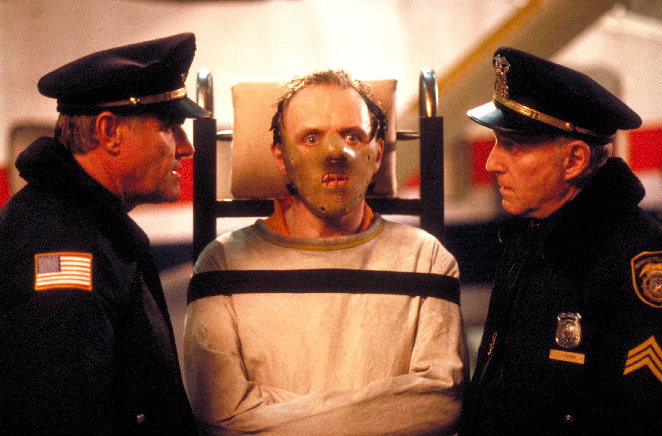 Anthony Hopkins in a mask with two police officers around him