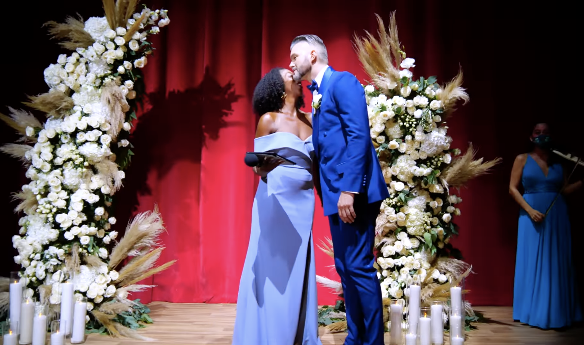 Emile greeting the officiant who&#x27;s wearing an off-the-shoulder dress