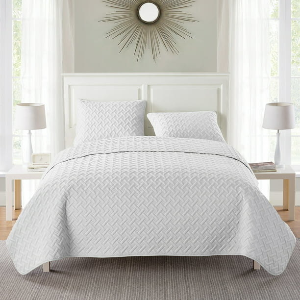 A bed with all white blanket and pillows