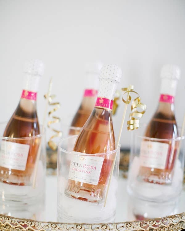 Bottles of Stella Rosa wine in clear glasses with ribboned stir sticks