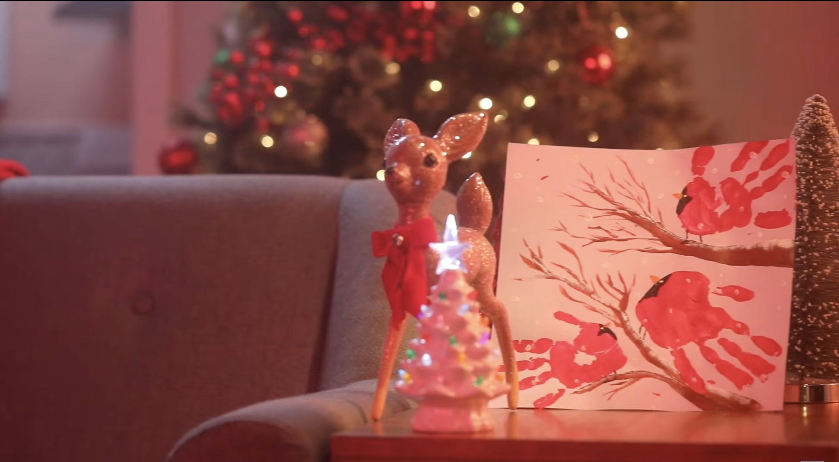 A handprint painting of "birds" on an end table in front of a tree