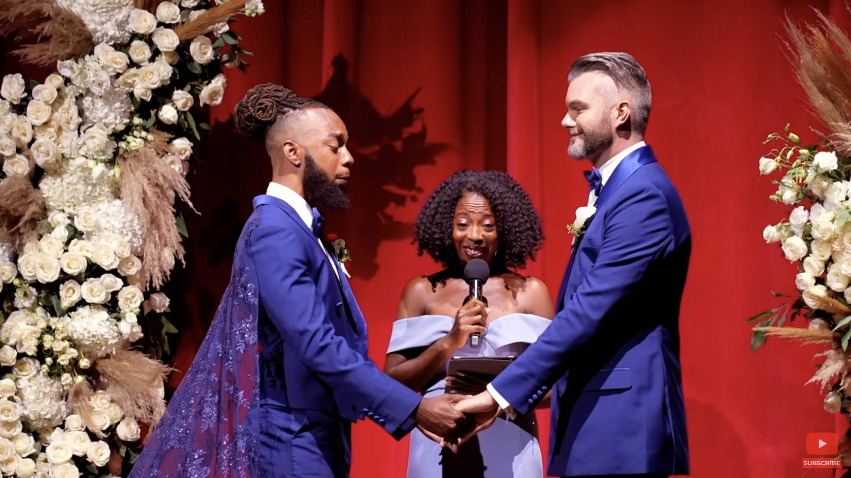 The couple holding hands at the altar