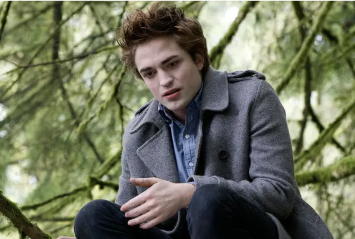 Robert Pattinson crouches in a peacoat