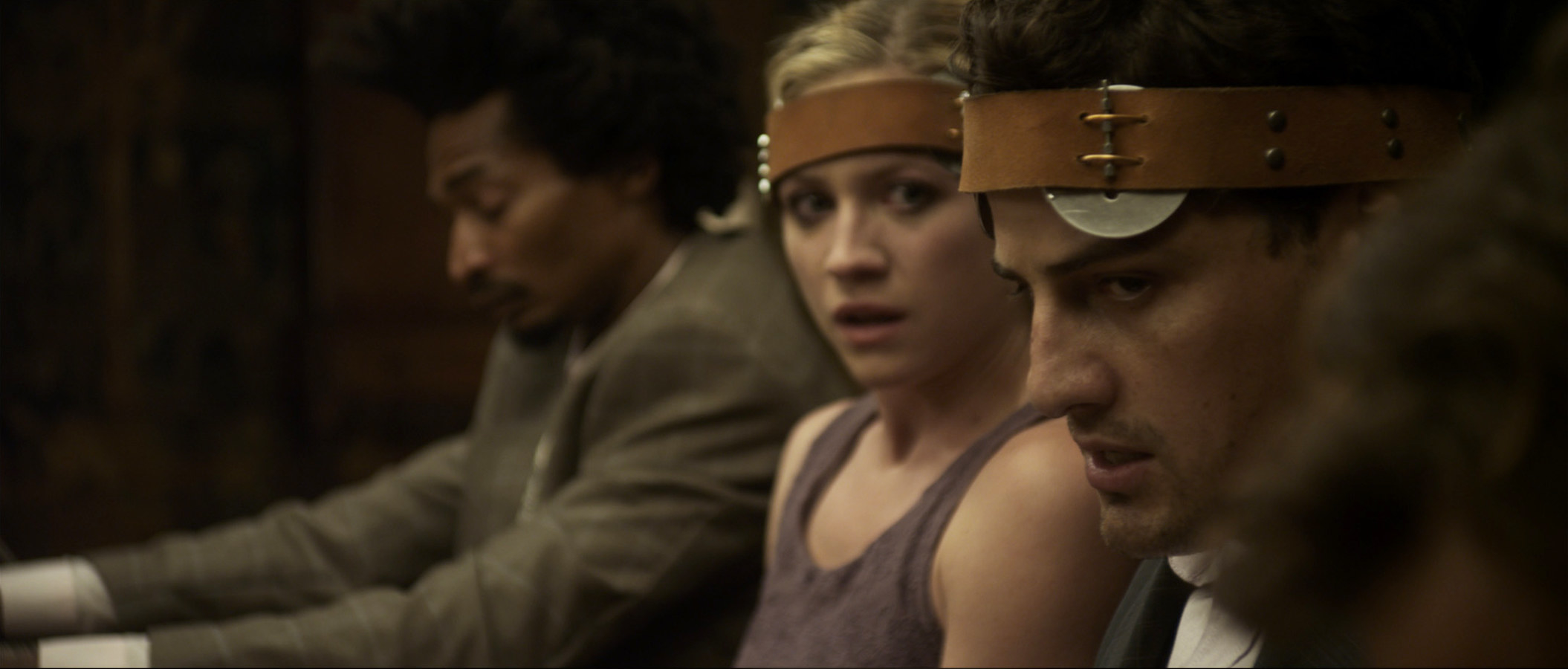 People sit at a table with electric devices attached to their heads