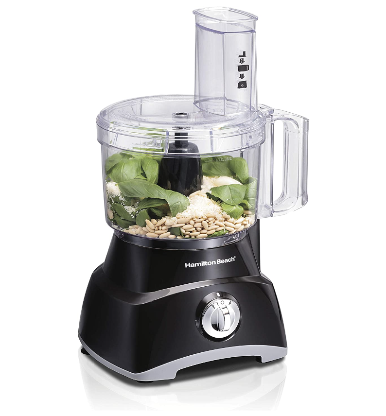 the food processor with pine nuts, cheese, and pesto inside