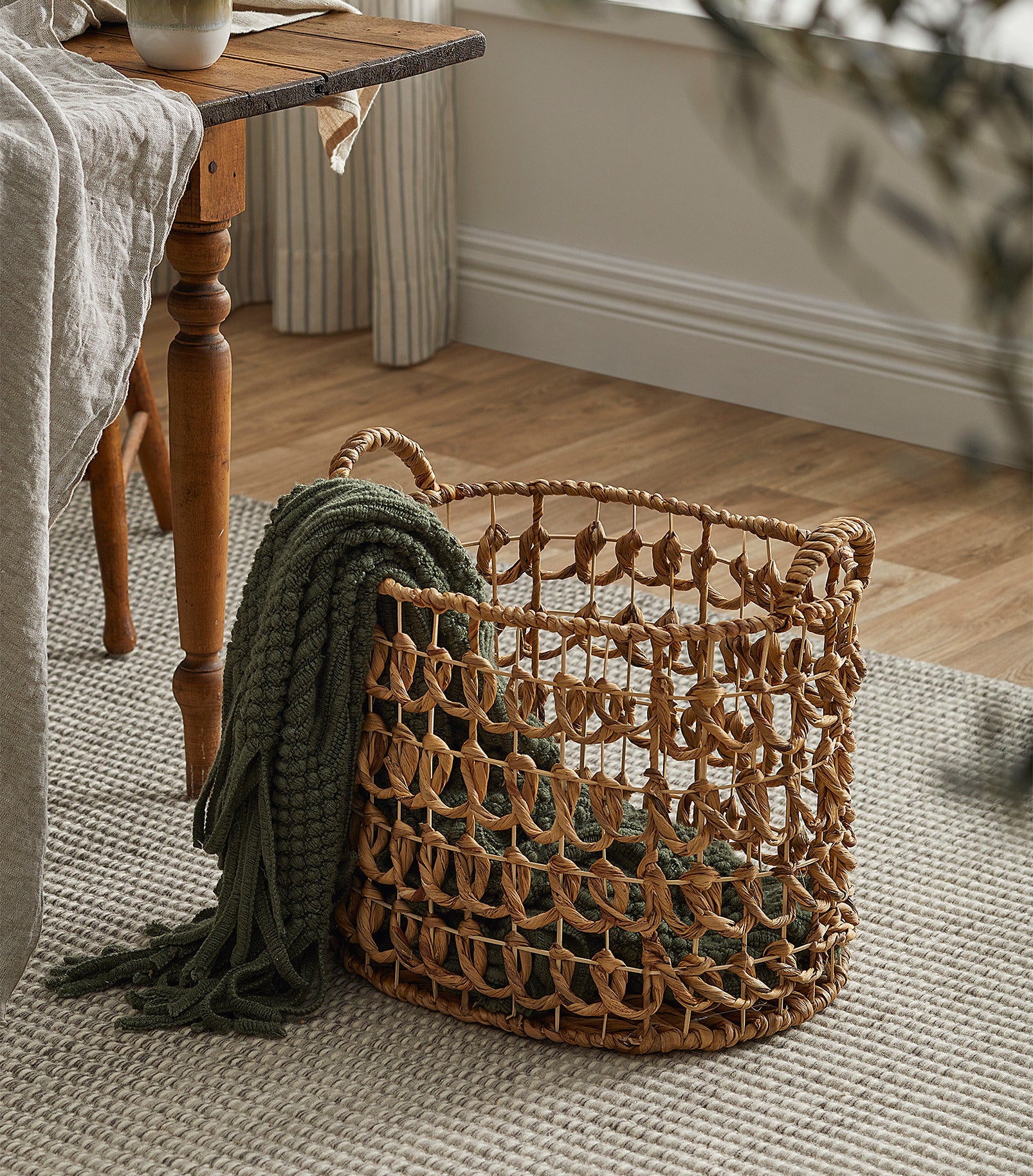 a rustic woven basket with a throw blanket inside
