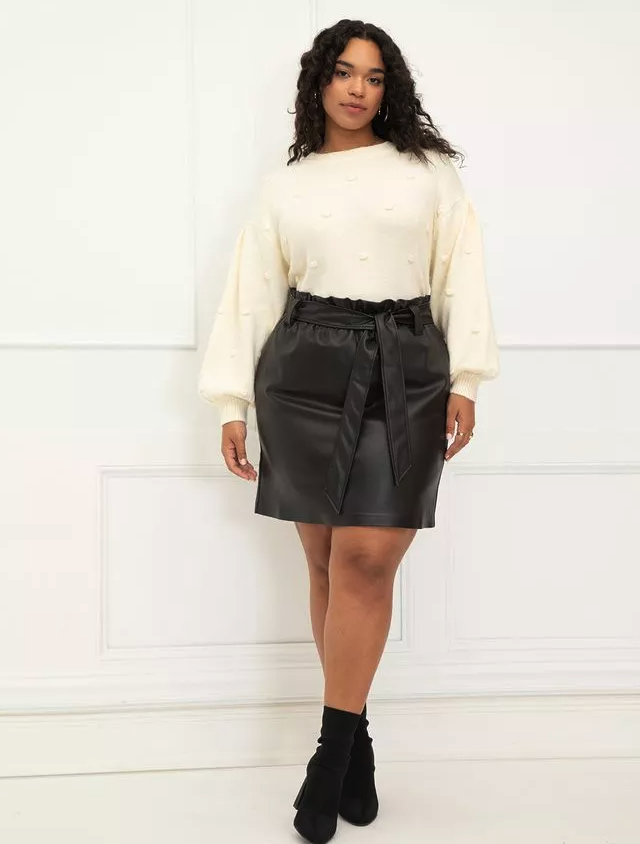 model wearing the black skirt with a cream sweater