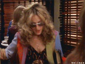 a gif of Carrie Bradshaw from Sex and the City putting a shopping bag on a table