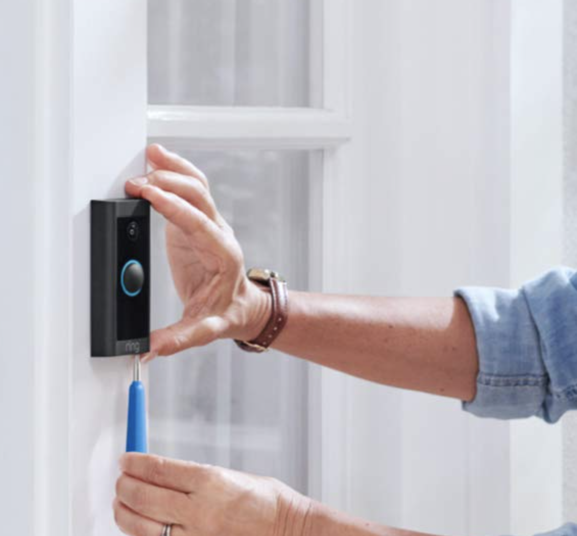 someone installing their doorbell on a door
